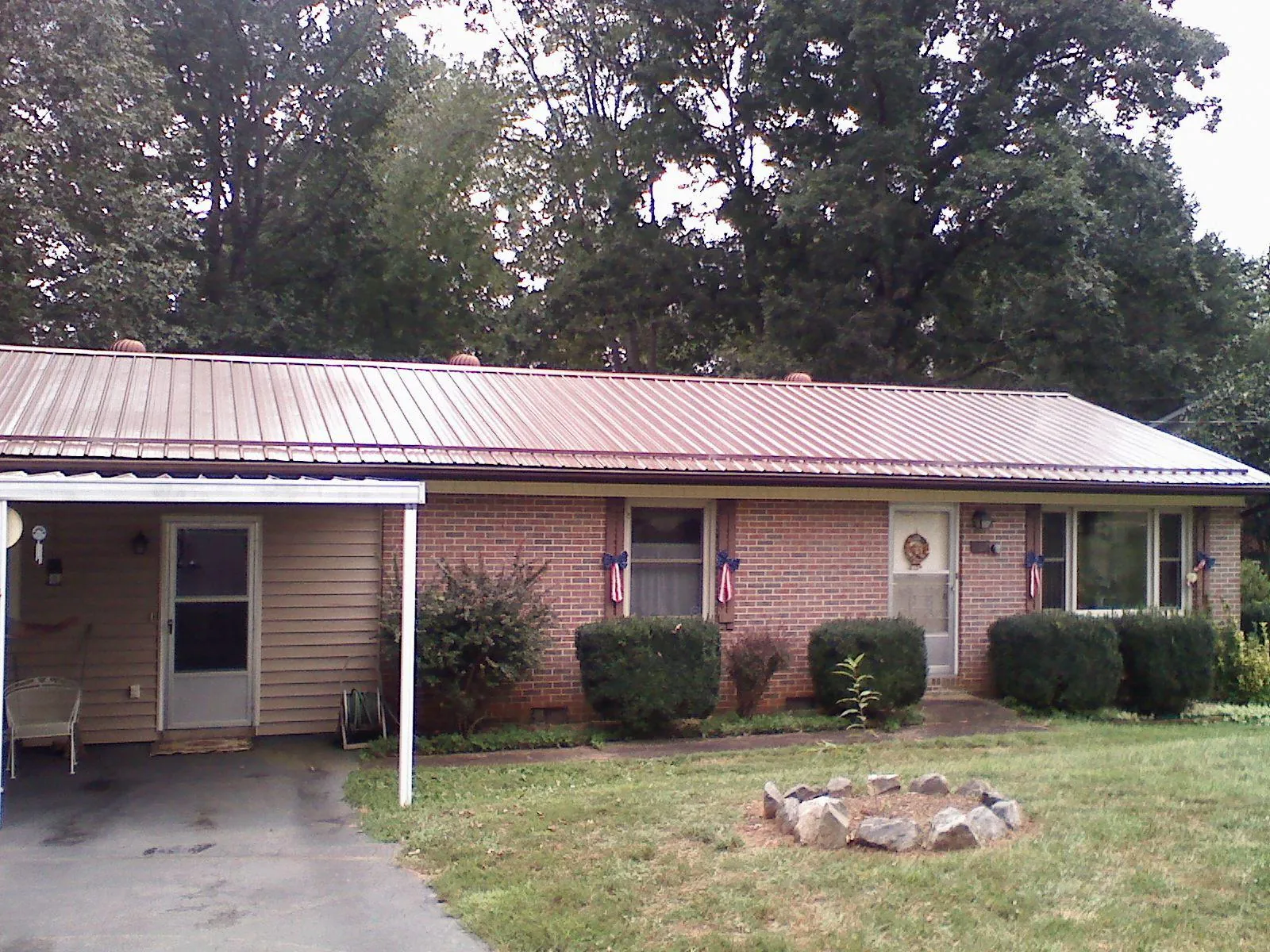 Bronze metal roof and carport on a brick ranch home — Roof Repair work by our crew in Red Rock